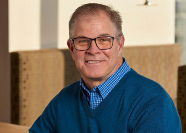 Brad Allen in a blue sweater posing for the camera